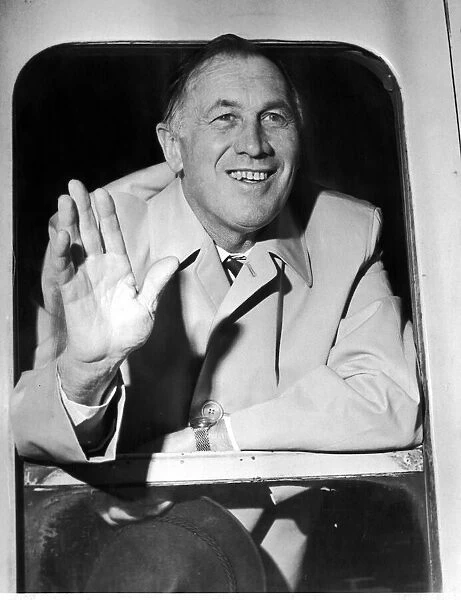 Manchester City Manager Joe Mercer waves to well wishers as the teams train pulls out of