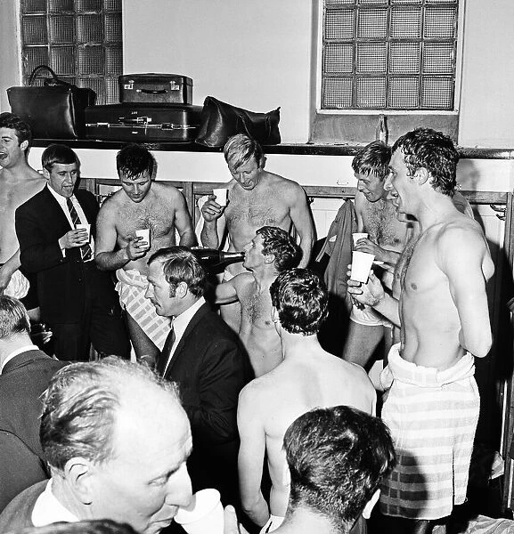 Manchester City players celebrate with champagne in the dressing room after sealing