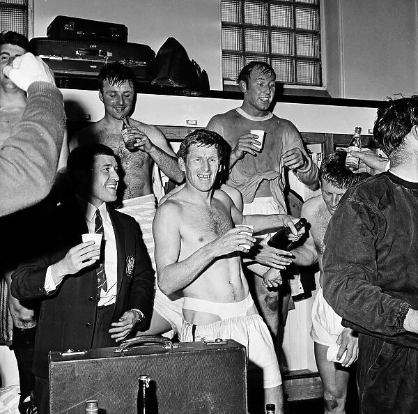 Manchester City players celebrate with champagne in the dressing room after sealing