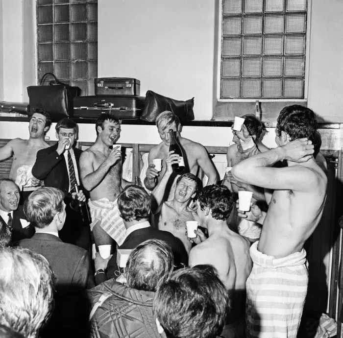 Framed Print : Manchester City players celebrate with champagne in the dressing room after sealing Framed Print : Manchester City players celebrate with champagne in the dressing room after sealing