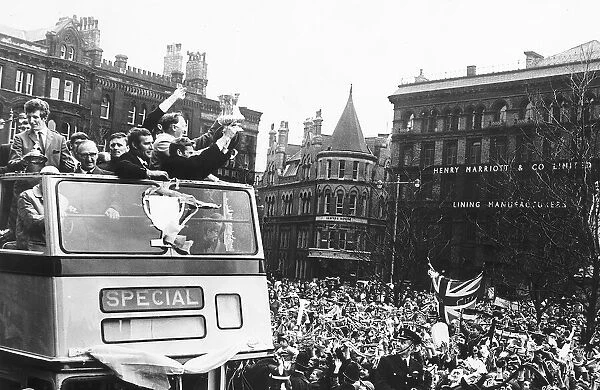 Manchester City team proudly show their supporters the FA Cup as they arrive at the Town