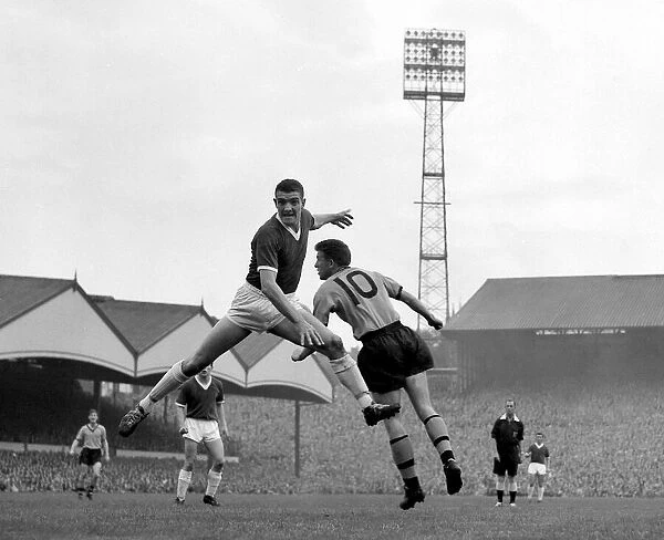 Manchester United defender Bill Foulkes jumps up for a high ball with Broadbent of