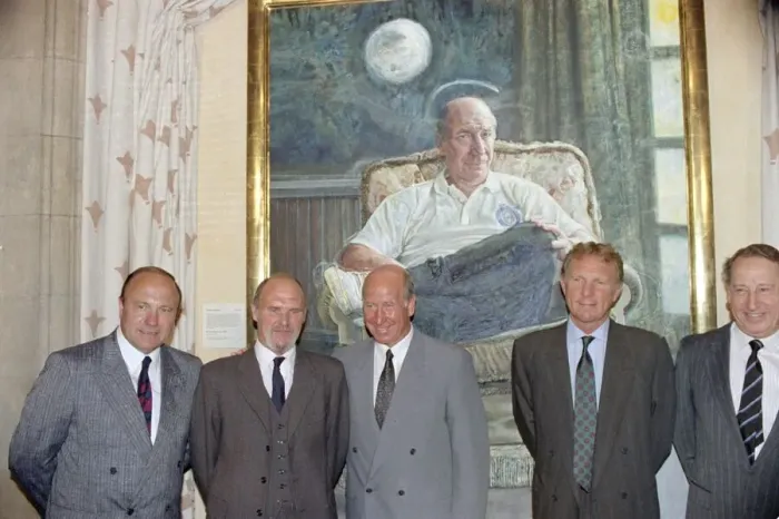 Framed Print : Manchester United director Bobby Charlton (centre) standing in front of a painting of him