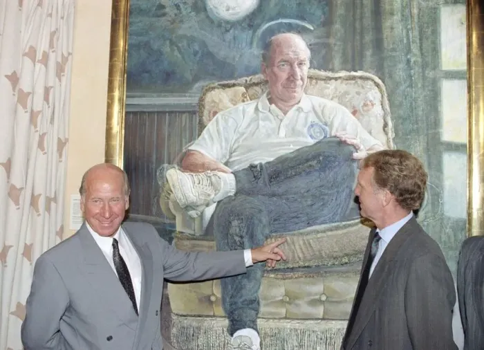 Framed Print : Manchester United director Bobby Charlton standing in front of a painting of him Framed Print : Manchester United director Bobby Charlton standing in front of a painting of him