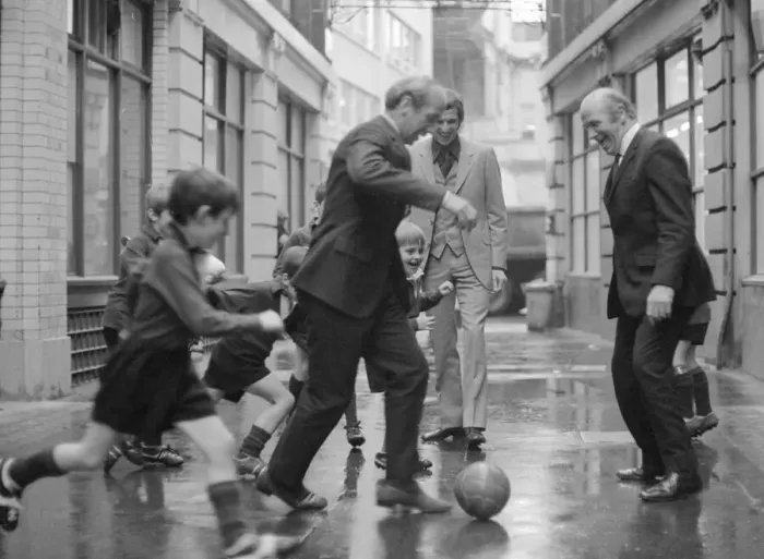 Framed Print : Manchester United and England footballer Bobby Charlton is chased in the street by
