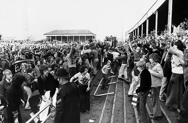 Manchester United fans celebrate on the pitch at Meadow Lane after a 2-2 draw against