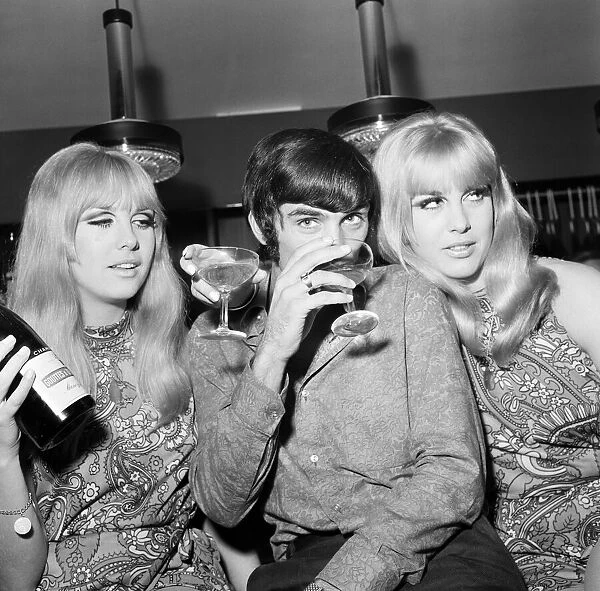 Manchester United footballer George Best celebrates the opening of his fashion boutique