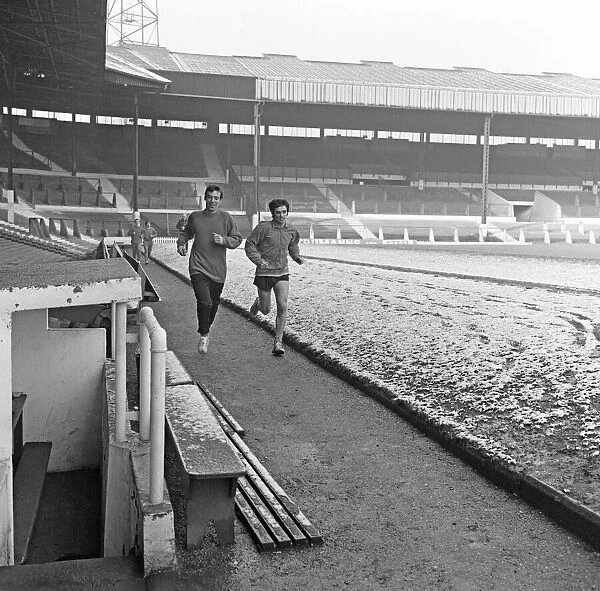 Manchester United footballer George Best running around a snow covered pitch at Old