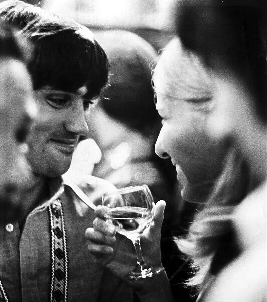 Manchester United footballer George Best talking to his girlfriend Eva Haraldsted holding