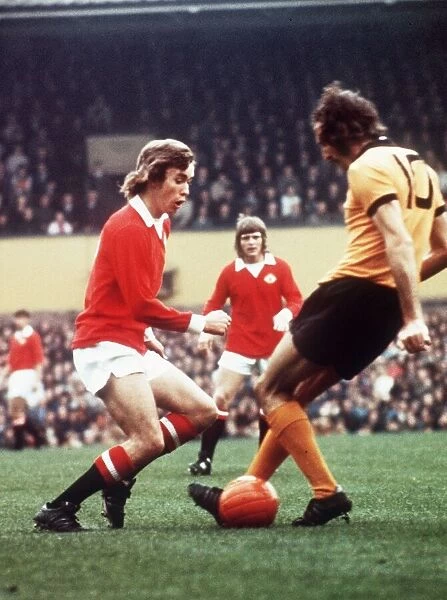 Manchester United footballer Sammy McIlroy battles for the the ball with Derek Dougan