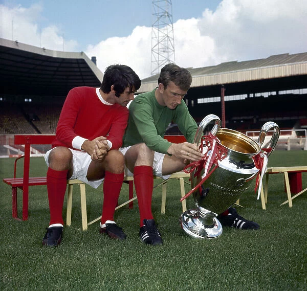 Manchester United footballers George Best and Alex Stepney admire the European Cup trophy