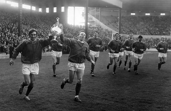 Manchester United footballers George Best and Nobby Stiles hold aloft the League