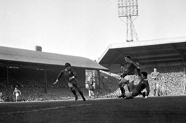 Manchester United goalkeeper Alex Stepney charges through the challenges of Liverpool