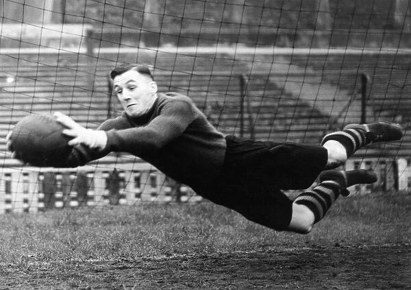 Manchester United goalkeeper Jack Crompton makes a flying save during a training session
