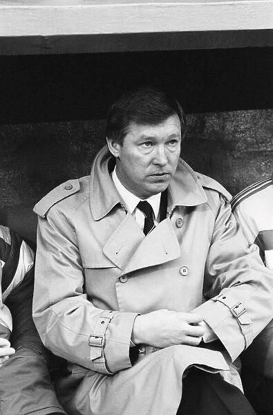 Manchester United manager Alex Ferguson checks his watch in the dugout during the League