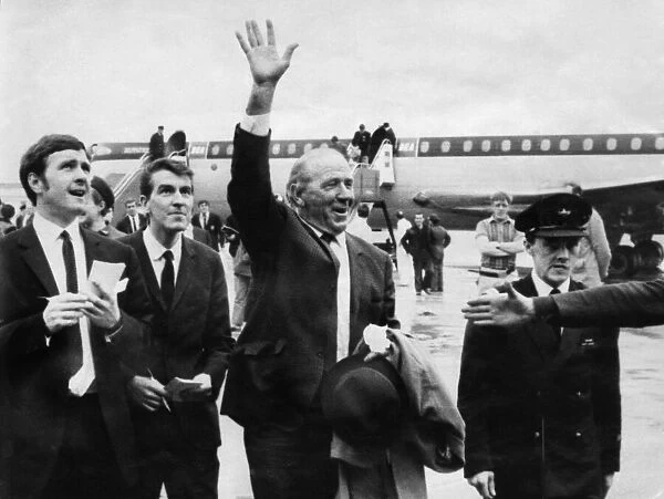 Manchester United manager Matt Busby gives the Old Trafford victory salute as he greets