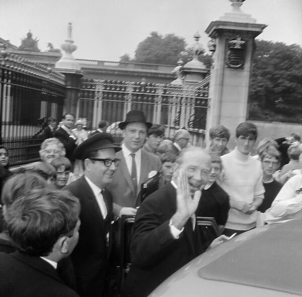 Manchester United manager Matt Busby waves as he arrives at Buckingham Palace to be