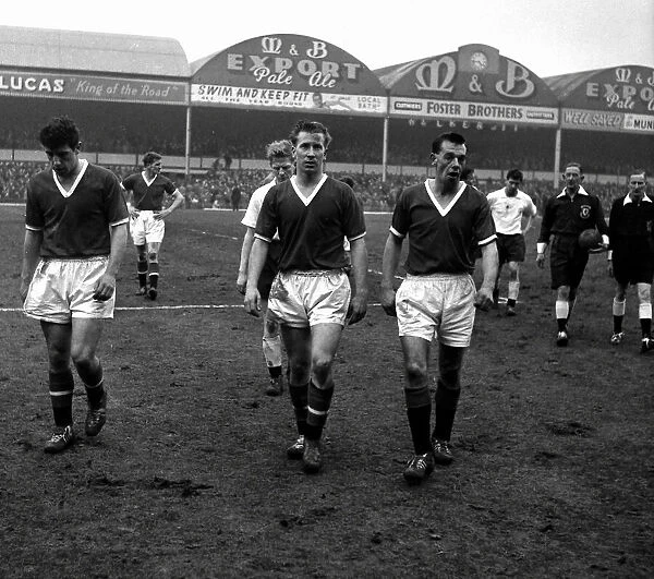 Manchester United players Colin Webster and Bobby Charlton pictured leaving the field