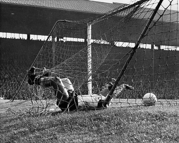 Manchester United v Tottenham. The Spurs half back Mullery ands up in the net after a