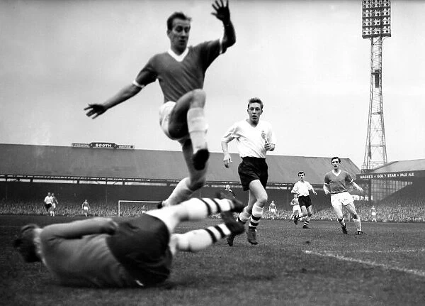 Manchester Uniteds Bobby Charlton jumps to clear the diving body of Bolton