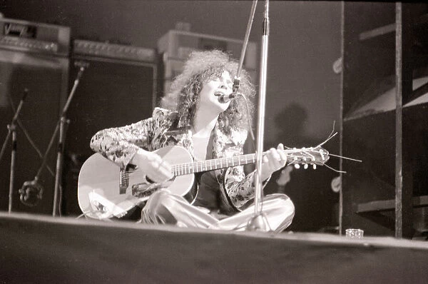 Marc Bolan in concert at th Empire Pool, Wembley. Sitting on stage cross legged