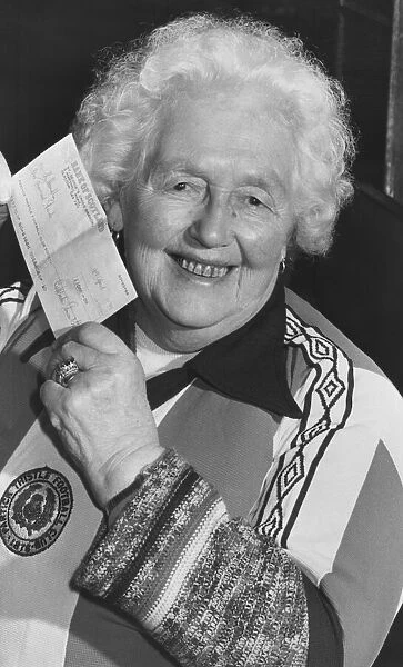 Margaret Cameron, 85, holds up her cheque for !000 after winning the first draw in