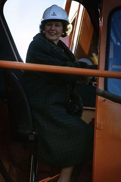 Margaret Thatcher sitting in a crane in drivers cabin while on an industrial visit