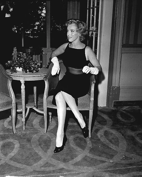 Marilyn Monroe sitting on a chair in her hotel foyer for Mirror Feature by Donal Zec
