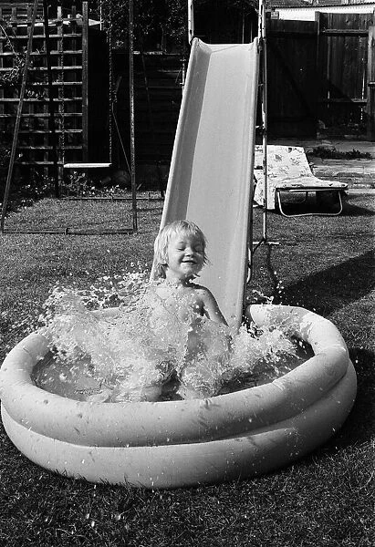 Mark Gordon cools off from the summer sun in his paddling pool. 28th June 1976