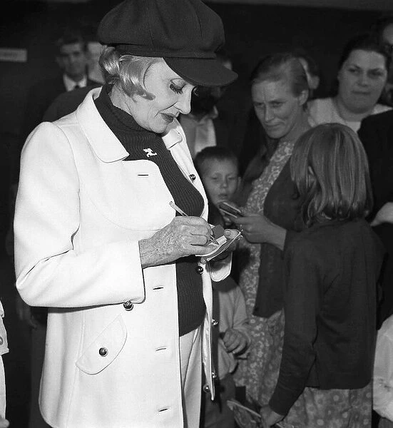 Marlene Dietrich arriving at Heathrow Airport from Paris, signing autographs