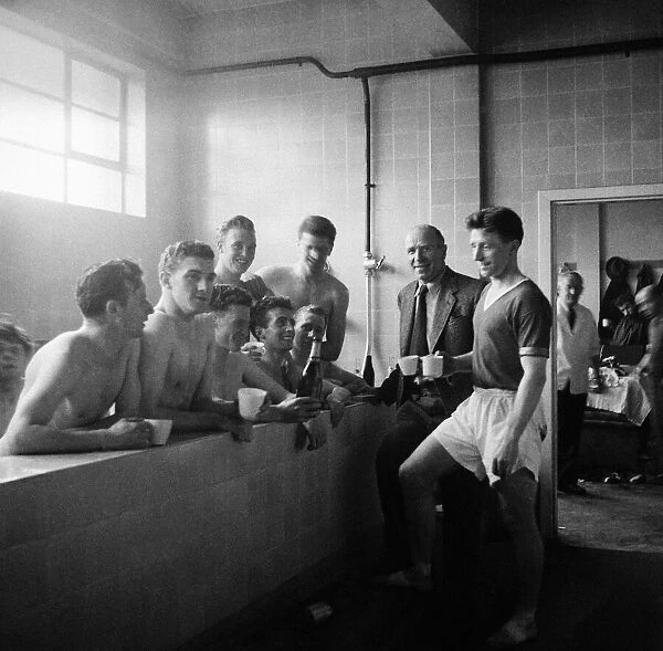 Matt Busby and players celebrating winning Division 1 with champagne in the bath