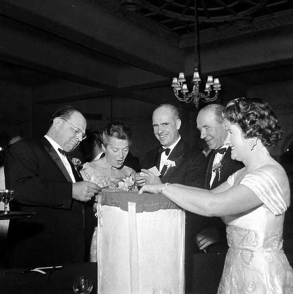 Matt Busby and his wife with Dr Maurer and wife pilling the winners of a lucky dip draw