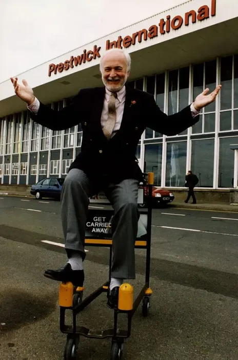 Framed Print : Matthew Hudson sitting on luggage trolly with hands in the air outside Prestwick Airport Framed Print : Matthew Hudson sitting on luggage trolly with hands in the air outside Prestwick Airport