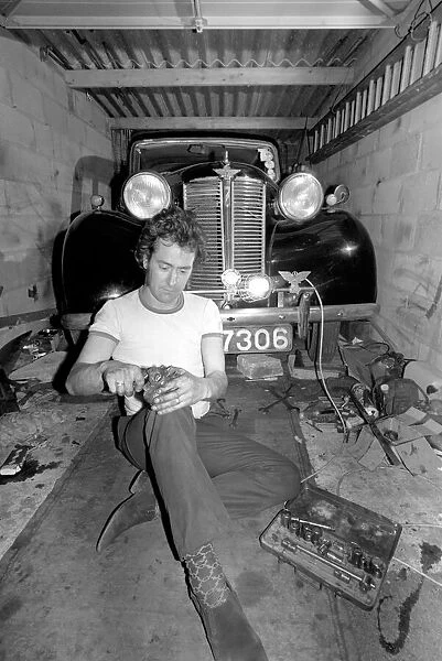 Mechanic underneath a car, making repairs April 1975 75-02158-013