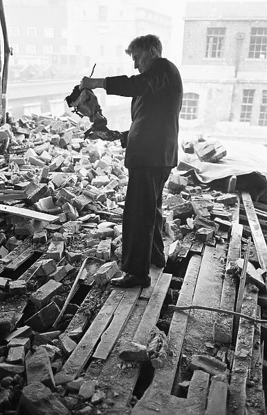 A member of staff holds a damaged instrument amongst the rubble of The Westminster
