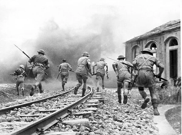 Members of the 8th Army move inland to take a railway station following Operation Husky