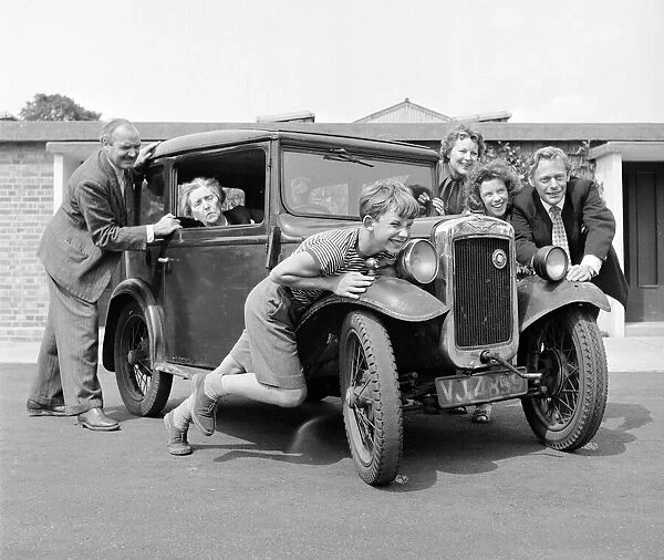 Members of the Goul family give grandmas car a push start Circa 1957