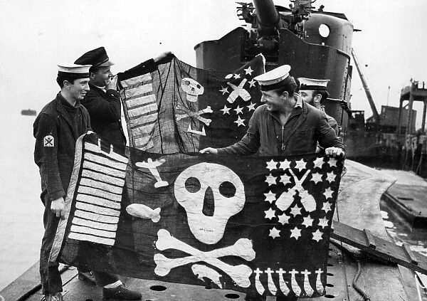 Members of HMS Torbays crew with the ships Jolly Rogers of success