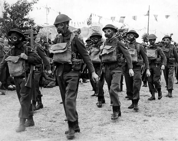 Members of the Home Guard march whilst wearing gas masks. 14  /  07  /  1942
