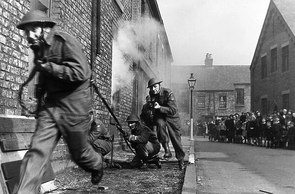 Members of the Home Guard running through a training exercise in a residential street in