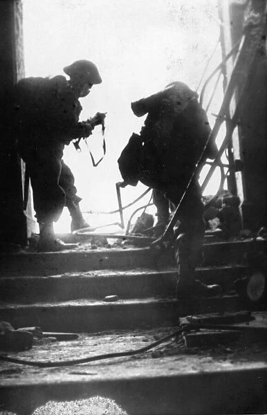 Two members of the home guard, silhouetted, in the doorway of a blitzed building