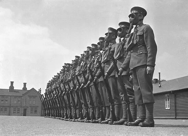 Members of the local regiment seen here on parade wearing gas maks