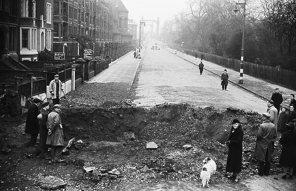 Members of the public inspect a crater in Albert Bridge Road, Battersea, London