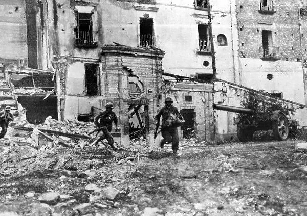 Men of American Infantry regiment moving across an open square in Itri while the town is