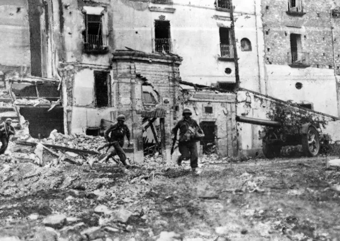 Framed Print : Men of American Infantry regiment moving across an open square in Itri while the town is Framed Print : Men of American Infantry regiment moving across an open square in Itri while the town is