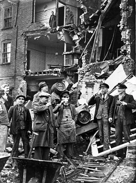 Men enjoy a drink at a bombed pub in Bristol. March 1941