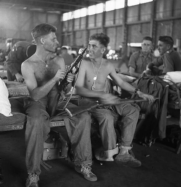 Men of the Lancashire Fusiliers camped in a hanger in Nairobi clean their weapons