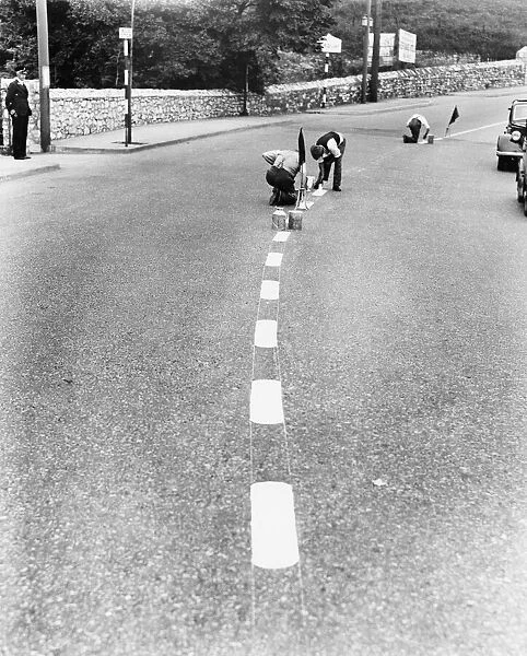 Men painting blackout lines on the road. 27th August 1939