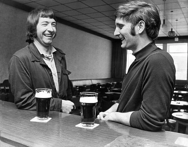 Two men have a pint of beer and a gossip at the bar