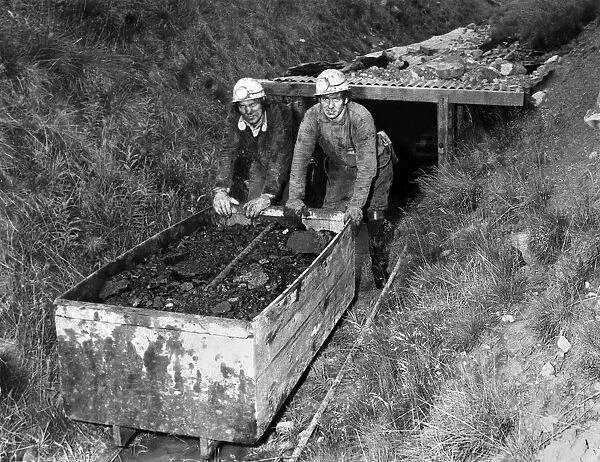 Two men pushing a cart full of coal in a mine. July 1978 P018160